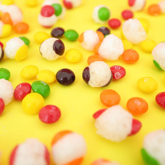 Colorful candy pieces on a yellow background