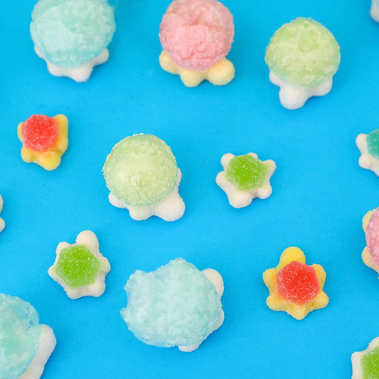 Colorful gummy turtle candies on a blue background