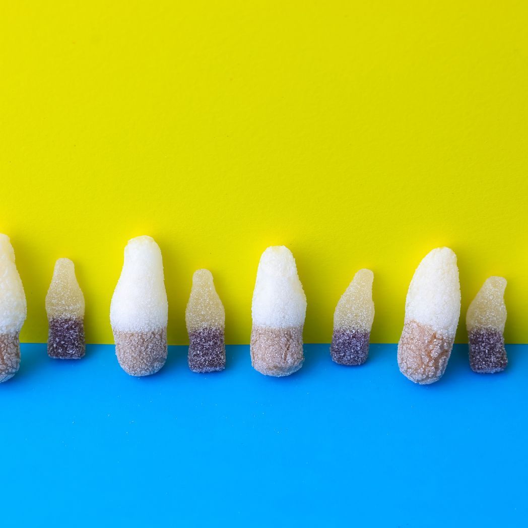 Row of colorful candy sticks on a blue and yellow background